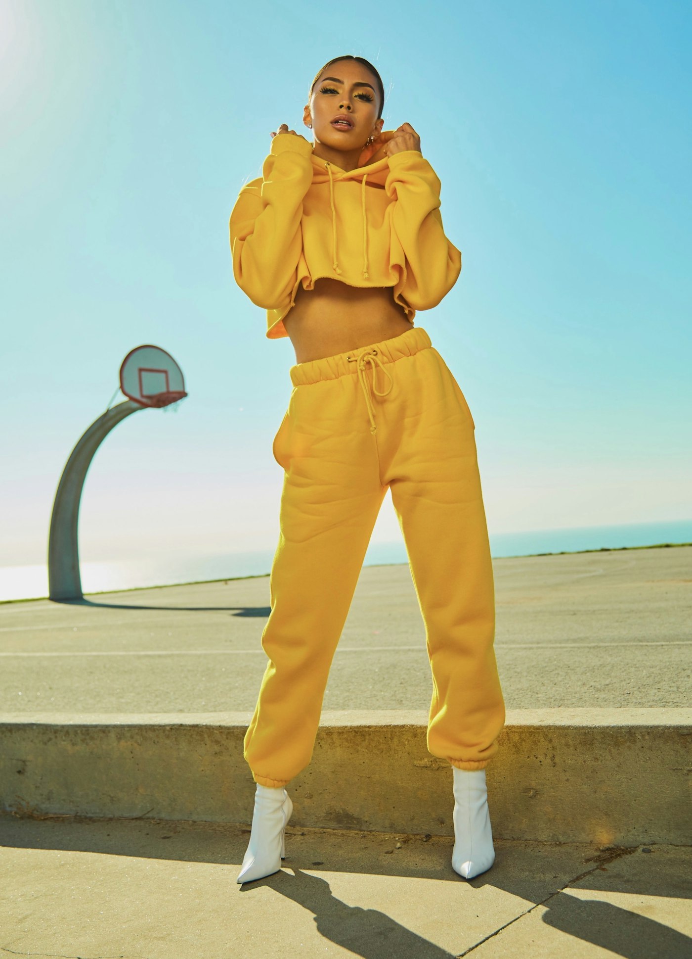 Model in a yellow cropped hoodie and joggers