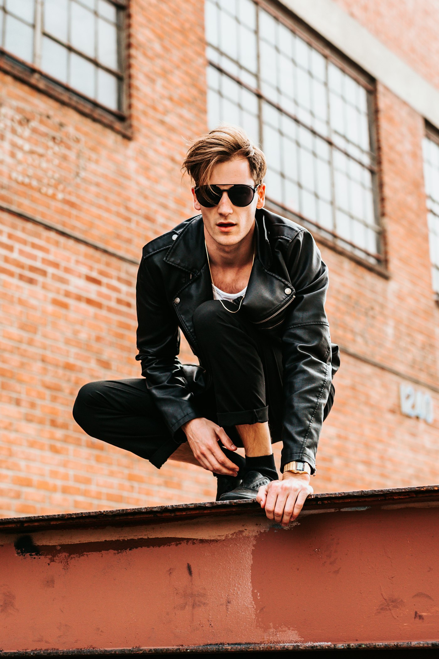 Model crouching in a black leather jacket